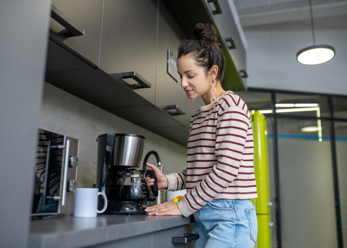 Young woman preparing coffee in the kitchen